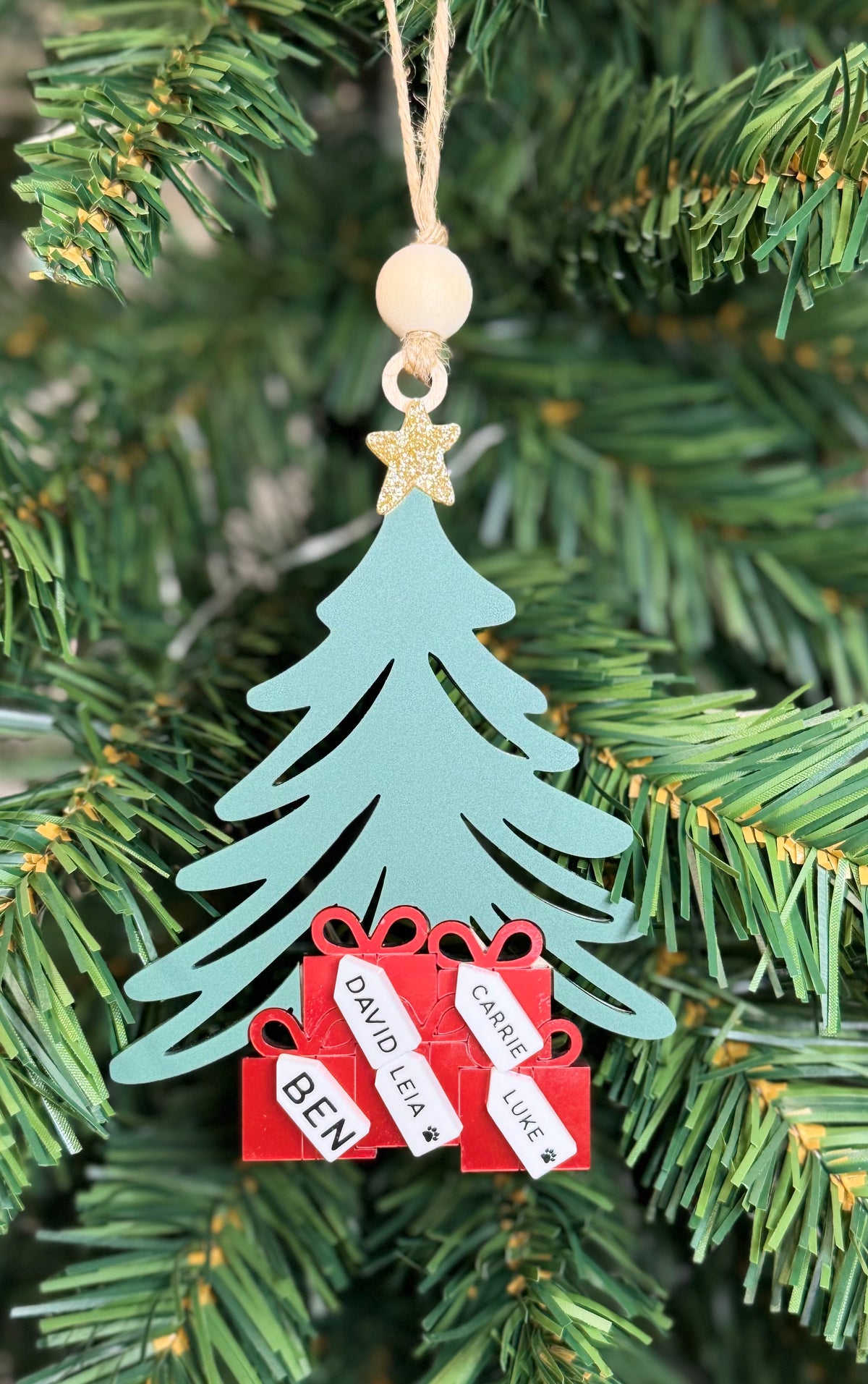 Personalized Christmas tree ornament with red presents and family name tags.