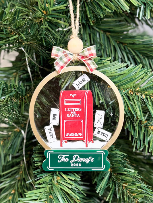 Personalized Letters to Santa shaker ornament with red mailbox and family name envelopes hanging on a Christmas tree